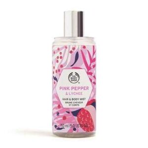 A tall cylindrical clear plastic bottle full of some clear liquid with a metallic silver spray lid and a clear label that has The Body Shop Pink Pepper & Lychee Hair & Body Mist written in bold black writing and some pictures of some bright pink lychees on it, on a white background.