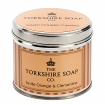 It's A Really Sunny Day In Yorkshire | The Yorkshire Soap Company Seville Orange & Clementine Tin Candle A short cylindrical silver tin with a silver lid and a bright orange label that has The Yorkshire Soap Company Seville Orange & Clementine Tin Candle written in bold black writing and a picture of a black crown on it, on a white background.