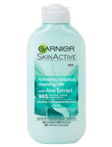 A tall flat cylindrical white plastic bottle with a white plastic lid that has Garnier Naturals written in bold black writing, Aloe Extract Cleansing Milk For Normal Skin written in bold white writing, and a picture of a dark green aloe vera plant on it, on a white background.