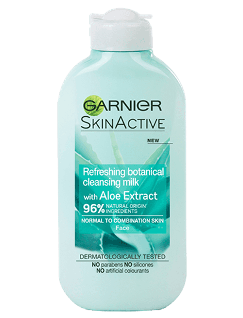A tall flat cylindrical white plastic bottle with a white plastic lid that has Garnier Naturals written in bold black writing, Aloe Extract Cleansing Milk For Normal Skin written in bold white writing, and a picture of a dark green aloe vera plant on it, on a white background.