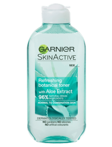 A tall flat cylindrical white plastic bottle with a white plastic lid that has Garnier Naturals written in bold black writing, Aloe Extract Toner For Normal Skin written in bold white writing, and a picture of a dark green aloe vera plant on it, on a white background.