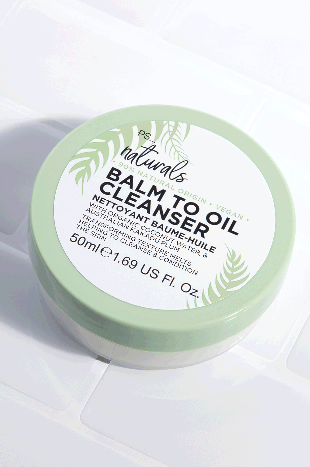 Psst!! I Have The Secret To Naturally Cleansed Skin | Primark PS... Naturals Balm To Oil Cleanser A short wide cylindrical white plastic tub with a light green lid and a white label that has Primark PS... Naturals Balm To Oil Cleanser written in bold black writing on it, on a white background.