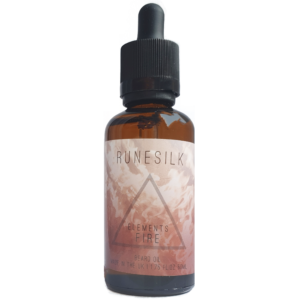 A short cylindrical brown glass bottle with a black rubber pipette lid and a white and gradient red label that has runesilk elements fire beard oil written in bold black writing and a picture of a red triangle on it, on a white background.