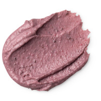 I Always Need My Beauty Sleep | Lush Beauty Sleep Face & Body Mask A small circular puddle of light purple face & body mask that has some pieces of dark brown aduki beans running through it, on a white background.