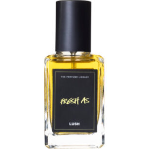 A short rectangular clear glass bottle full of some clear liquid with a black lid and a black label that has Lush Fresh As Perfume written in bold white writing on it, on a white background.