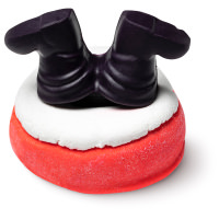 A large rectangular brick red chimney shaped bubble bar that has some snow on top of it and a black pair of boots shaped bath oil coming out of the top of it, on a white background.