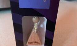 A large glass diamond shaped Car Air Freshener bottle inside a light brown cardboard box that has Carfume™ written in bold black writing on it, on a white background.