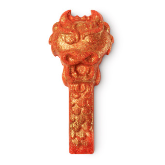 A small bright red dragons head and neck shaped bubble bar that has some gold lustre all over it, on a white background.