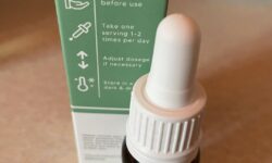 A tall cylindrical brown glass bottle with a white rubber pipette lid and a white label that has Nutrivive 500mg CBD Oil written in bold black writing on it, on a white background.