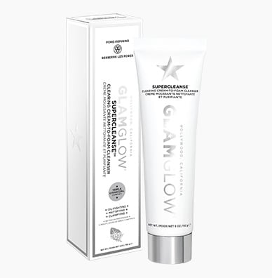 I Love Having A Super Cleansed Face | GlamGlow SuperCleanse™ Cream To Foam Cleanser A tall thin conical white Plastic Tube with a silver Plastic Lid that has GlamGlow SuperCleanse™ Cream To Foam Cleanser written in bold black writing on it next to a tall rectangular white cardboard box that has GlamGlow SuperCleanse™ Cream To Foam Cleanser written in bold black writing and a picture of a silver star on it, on a white background.