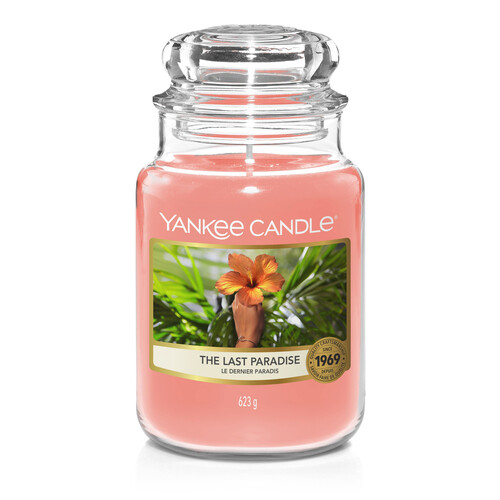 I've Finally Found Paradise | Yankee Candle The Last Paradise Collection A tall cylindrical Jar full of some light pink Wax with a label that has Yankee Candle written in white writing, the last paradise written in black writing, and a picture of some multicoloured flowers on it, on a white background.