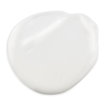 A medium circular puddle of bright white eye cream, on a white background.