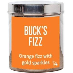 A short cylindrical silver metal tin with a golden orange label that has bird & blend tea company Buck’s Fizz Loose Leaf Tea written in bold white writing on it, on a white background.