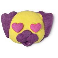 A small bright yellow and dark purple pug shaped bubble bar that has some bright red heart shaped eyes and is covered in some silver lustre, on a white background.