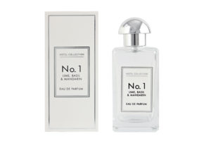 The Different And Intriguing Scents Of A Hotel | Aldi Hotel Collection Lime, Basil & Mandarin Eau De Parfum A tall rectangular clear glass bottle full of some clear liquid with a metallic silver lid and a white label that has Aldi Hotel Collection Lime, Basil & Mandarin Eau De Parfum written in bold black writing on it next to a tall rectangular white cardboard box that has Aldi Hotel Collection No.1 Lime, Basil & Mandarin Eau De Parfum written in bold black writing on it, on a white background.