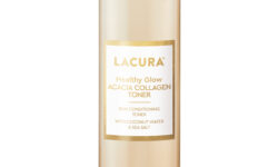 A tall cylindrical clear plastic bottle full of some translucent blue liquid with a bright gold lid that has Aldi Lacura Healthy Glow Acacia Collagen Toner written in bold gold writing on it, on a white background.