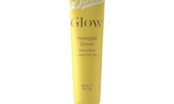 A long thin cylindrical bright yellow Plastic tube that has boots written in bold white writing and glow pineapple serum written in bold gold writing on it, on a white background.