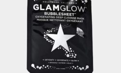 A tall rectangular black plastic pouch that has GlamGlow BubbleSheet™ Oxygenating Deep Cleanse Mask written in bold silver writing and a picture of a silver star on it, on a white background.