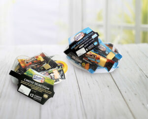 four large rectangular blocks of bright yellow cheese inside a clear plastic tray that has Ilchester Cheese Snack Selection written in bold white writing and a picture of a black stripe on it, on a white background.