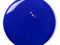A medium circular puddle of dark blue shower gel, on a white background.