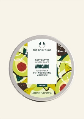 My Skin Is Having Avocado For Breakfast | The Body Shop Avocado Body Butter A short cylindrical light green plastic tub with a silver aluminium Lid that has The Body Shop Avocado Body Butter written in dark green writing and some pictures of some large bright green avocados on it, on a white background.