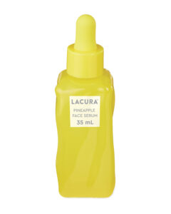 A tall rectangular yellow glass bottle full of some clear liquid with a yellow rubber pipette lid and a white label that has Aldi Lacura Pineapple Face Serum written in bold black writing on it, on a white background.