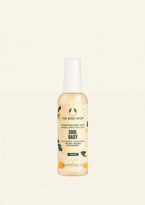 A tall cylindrical clear plastic bottle full of some pale yellow liquid with a black plastic spray pump lid that has The Body Shop Cool Daisy Hydrating Body Mist written in dark green writing and some pictures of some pale yellow Daisies on it, on a white background.