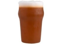 A short cylindrical dark amber pint of lager shaped block of soap that has a layer of bright white foam on top of it, on a white background.