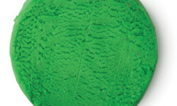 A large cylindrical block of bright green plasticine, on a white background.