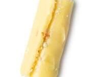 A long thick cylindrical block of bright yellow solid Massage Oil, on a white background?