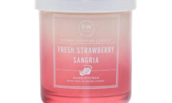 A short cylindrical clear glass Jar full of some bright pink wax with a bright pink label that has DW Home Candles Fresh Strawberry Sangria written in bold white writing and a picture of a white Flamingo on it, on a white background.