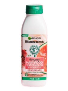 A short rectangular bright pink Plastic Bottle with a bright green lid and a bright green label that has Garnier Ultimate Blends Hair Food Watermelon Conditioner written in bold black writing and a picture of a Watermelon on it, on a white background.