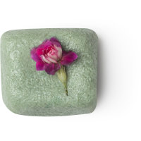 A short rectangular block of sandy yellow Sugar Scrub that has some pieces of Bamboo Stem running all the way through it, on a white background.