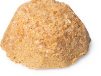 A large circular mound of sandy yellow salt scrub, on a white background.