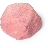A large circular mound of pale pink salt scrub, on a white background.