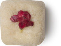 A short rectangular block of light green Sugar Scrub that has some bright green petals embedded on it, on a white background.