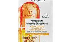 A tall rectangular white plastic pouch that has Garnier SkinActive Vitamin C Anti Fatigue Ampoule Sheet Mask written in bold green writing and a picture of a large bright orange and yellow Vitamin C Tablet on it, on a white background.