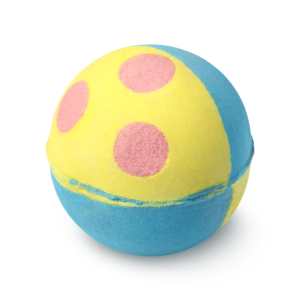 A large bright blue and yellow spherical shaped bath bomb that has some bright pink spots on top of it, on a white background.