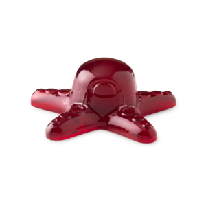 A large dark red octopus shaped block of shower jelly that has a red Eye and some red suckers on it, on a white background.