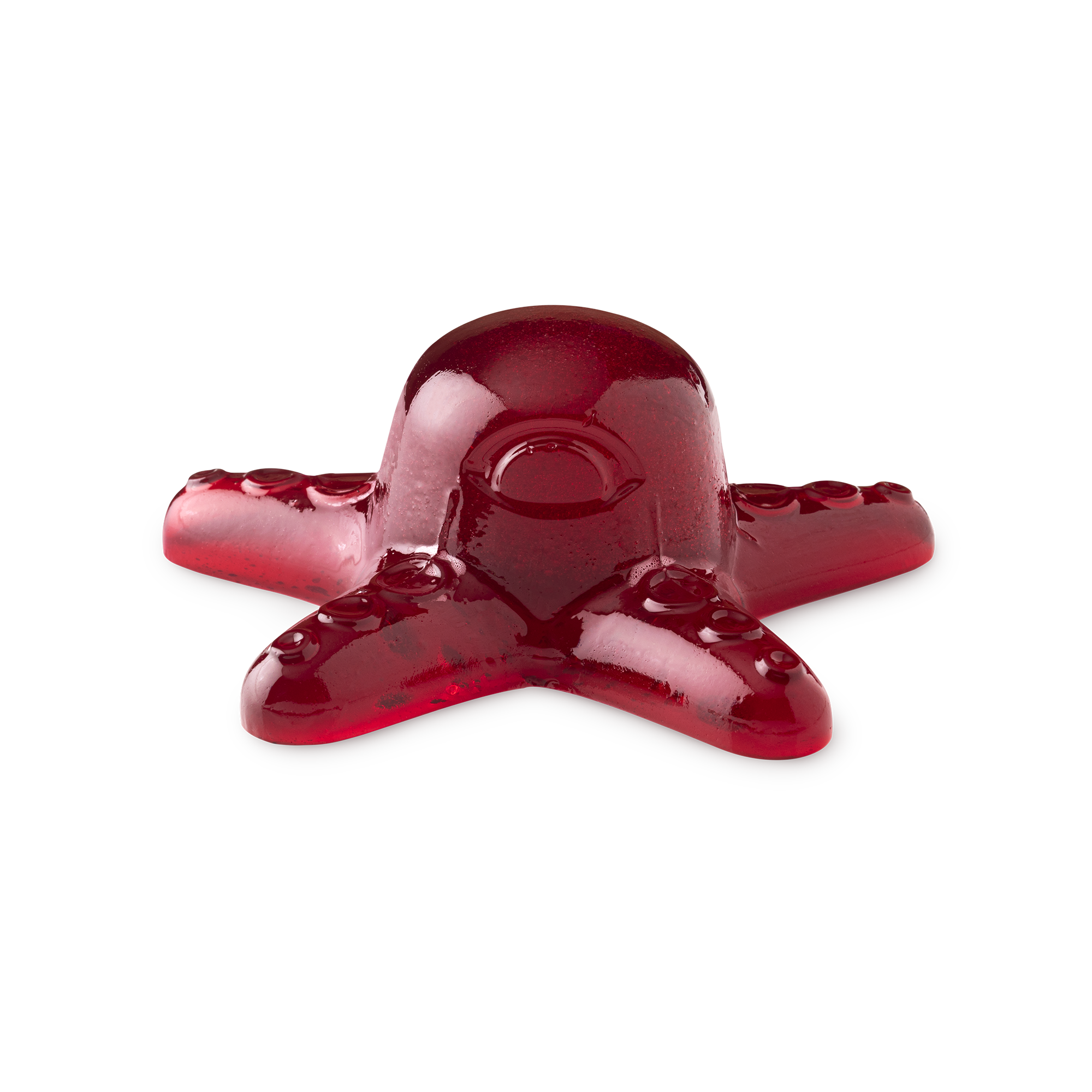 A large dark red octopus shaped block of shower jelly that has a red Eye and some red suckers on it, on a white background.