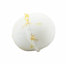 A large spherical bright white bath bomb that has some streams of bright yellow coming out of the side of it, on a white background.