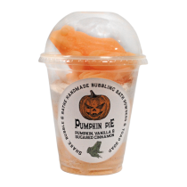 A tall cylindrical clear plastic cup full of some bright orange powder with a clear plastic dome lid and a white label that has The Yorkshire Soap Company Pumpkin Pie Shake, Bubble & Bathe written in bold black writing and a picture of a large bright orange pumpkin on it, on a white background.