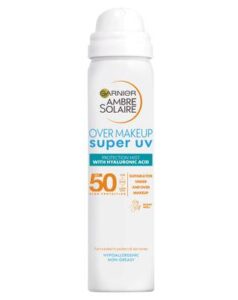 A tall cylindrical Metallic White Aerosol Can with a white plastic lid that has Garnier written in bright blue writing, Ambre Solaire Over Makeup Super UV Protection Mist written in bold black writing, and SPF50 written in bold gold writing on it, on a white background.