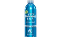 A tall cylindrical metallic light blue bottle with a clear plastic pump lid that has King of Shaves Refillable Sensitive Shave Gel written in bold white writing on it, on a white background.