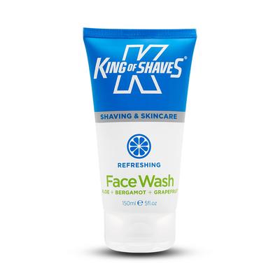 A tall conical gradient bright blue and white plastic tube that has King of Shaves written in bold white writing and Refreshing Face Wash written in bright green writing on it, on a white background.