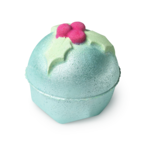 A large bright white rounded hexagonal shaped bath bomb that has a dark green and red 3d Holly Leaf and Berries on top of it and some dark green lustre on it, on a white background.