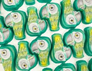 A large parrot’s head shaped bright green bath bomb that has a light grey beak, a yellow neck and a large white eye engraved on it, on a white background.