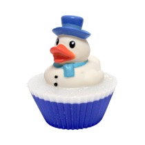 A large cylindrical bright white cupcake shaped block of soap that has a bright blue pond design and a small bright white rubber duck wearing a bright blue hat and scarf on top of it, on a white background.