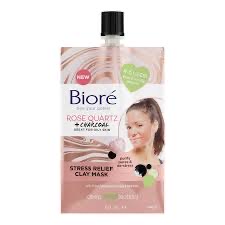 The Fresh & Floral Smell Of Roses Is Just So Relaxing | Biore Rose Quartz + Charcoal Stress Relief Clay Mask A short rectangular gradient pink and white plastic pouch with a black plastic screw top lid that has Biore Rose Quartz + Charcoal Stress Relief Clay Mask written in bold black writing and a picture of a woman’s face on it, on a white background.