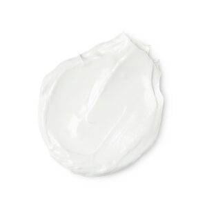 A medium circular puddle of some creamy white hand cream, on a white background.